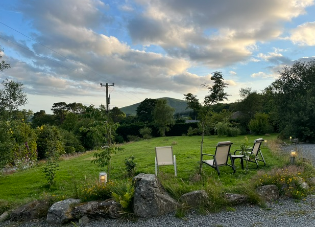 Chairs set out on the lawn, the hill catching evening sun