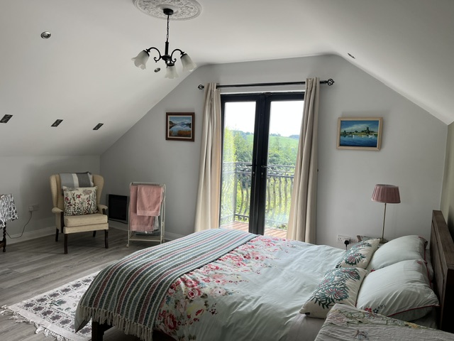 The balcony room — French doors open to the hills