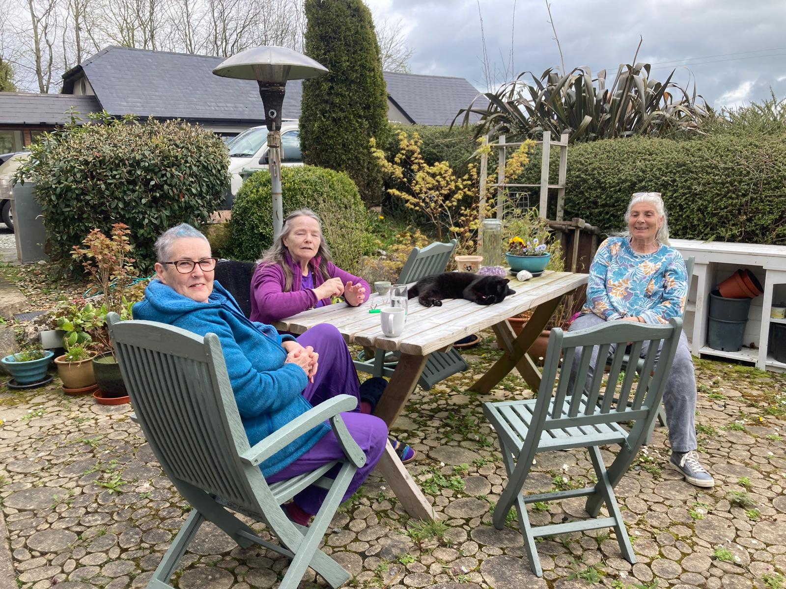 Tea at the garden table — and the cat taking the best seat